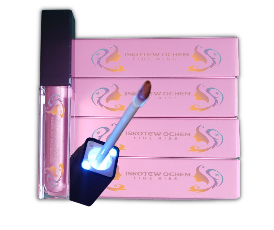 Fire Kiss Lip Gloss. The color SKWESIS illuminates a soft pink glow. The lip gloss is packaged with an applicator wand that lights up when the lip gloss is applied.